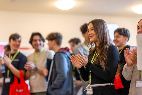 Gruppe von Personen mit Namensschildern applaudiert bei der Eröffnung – Szene vom sprungbrett SPEED DATING in Nürnberg.