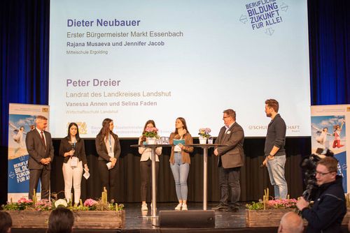 Dieter Neubauer, Bürgermeister Markt Essenbach, sowie Peter Dreier, Landrat des Landkreises Landshut, werden von Schülerinnen auf der Bühne vorgestellt.