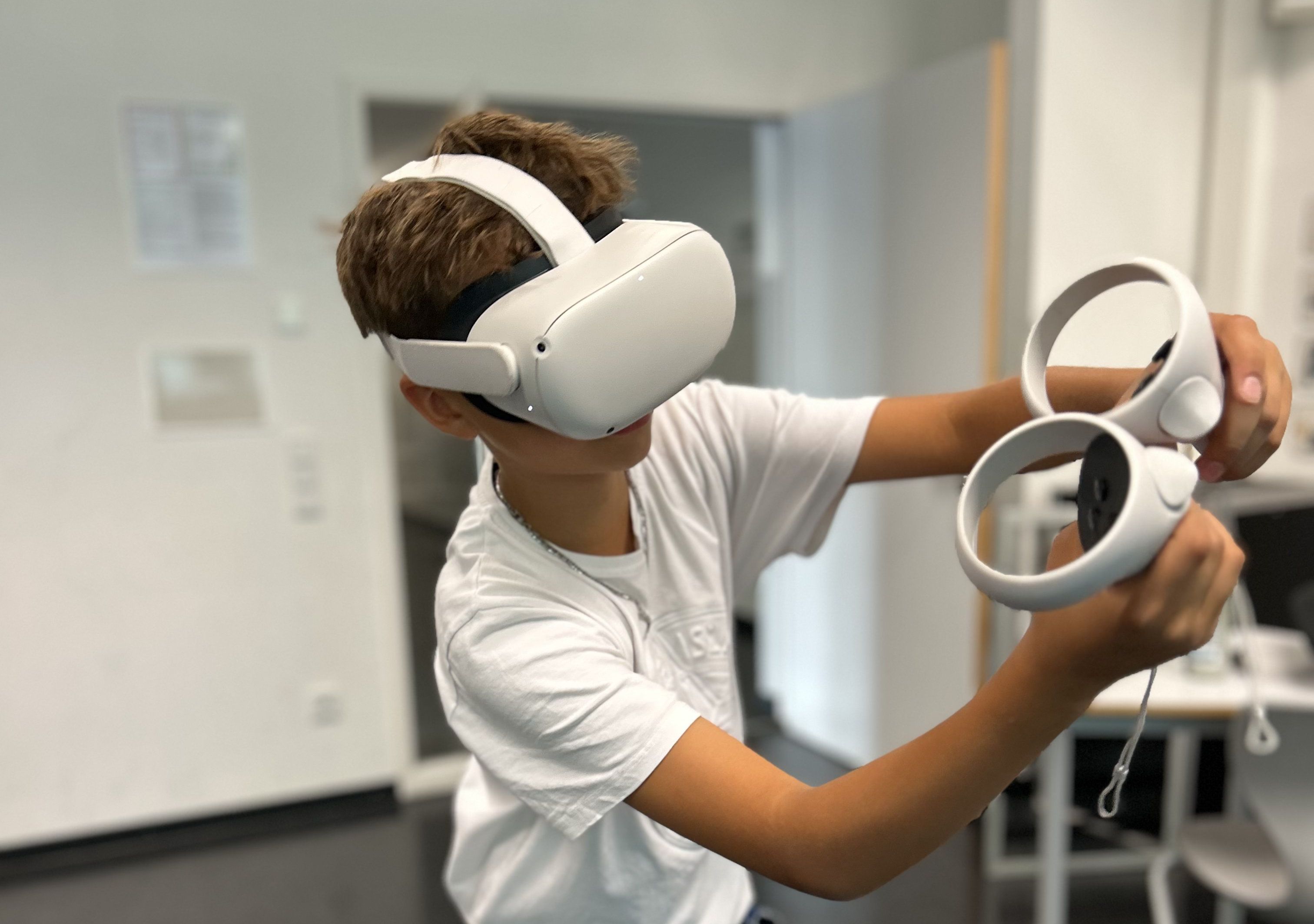 Eine Schülering steht in einem Klassenzimmer und spielt mit der Virtual Work Experience