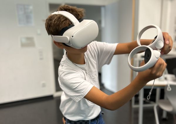 Eine Schülering steht in einem Klassenzimmer und spielt mit der Virtual Work Experience