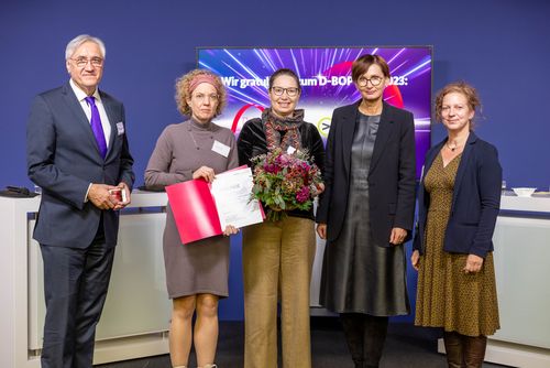 Das Team der Virtual Work Experience nimmt den Preis von Bundesbildungsministerin Bettina Stark-Watzinger entgegen.