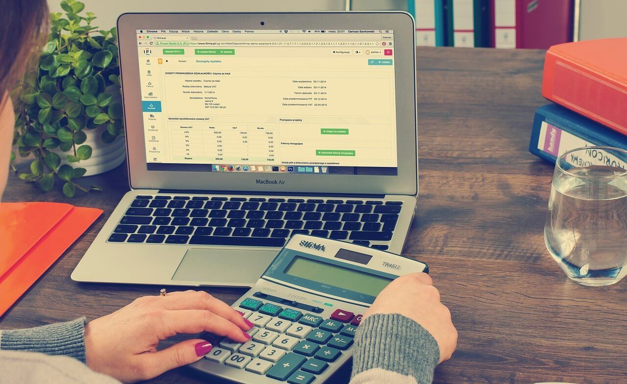 Beruf des Monats Steuerfachangestellter Arbeitsplatz eines Steuerfachangestellten mit Laptop und Taschenrechner