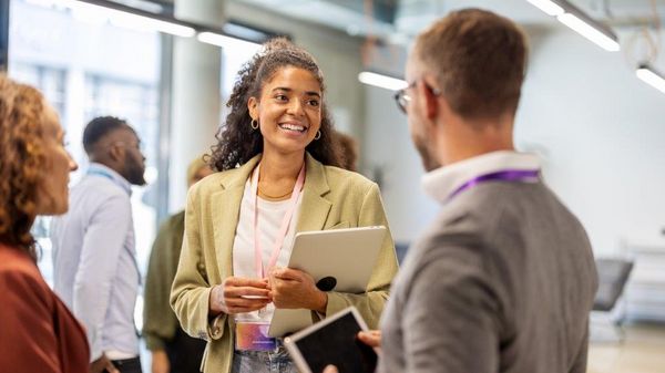 Zwei Personen, eine Frau und ein Mann, auf einer Veranstaltung im Gespräch.