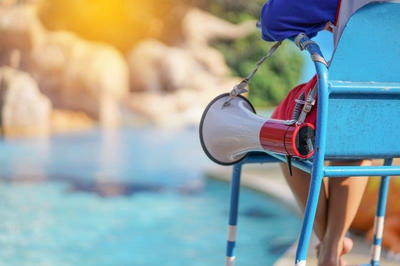 sprungbrett beruf des Monats Fachangestellter für Bäderbetriebe Ein Hochstuhl, an dem ein Megafon hängt. Im Hintergrund ein Pool