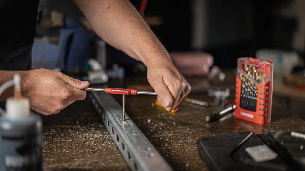 Beruf des Monats Feinwerkmechaniker In ein Metall-Werkstück wird ein Gewinde geschnitten.