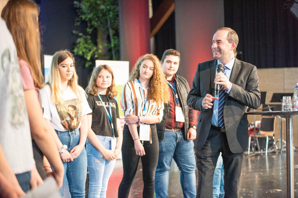 Schülerinnen und Schüler des Landkreises Essenbach befragen Wirtschaftsminister Hubert Aiwanger auf der Bühne zu seinem beruflichen Werdegang.