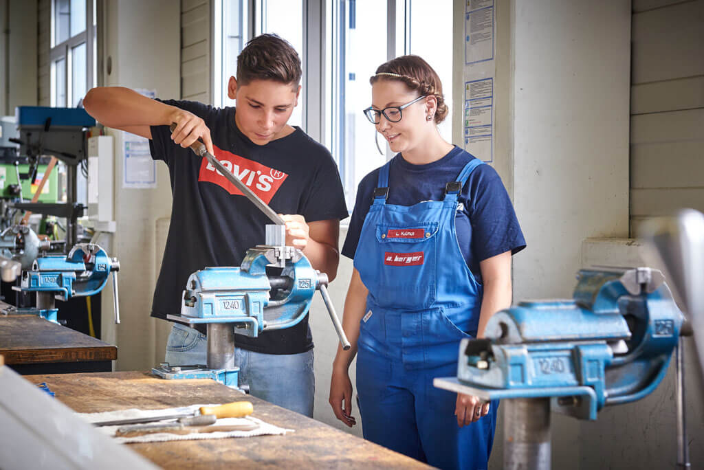 Zwei Azubis beim bearbeiten eines Werkstückes mit der Feile