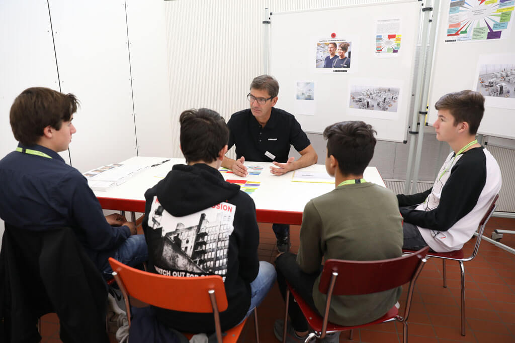 Vier Schüler beim SPEED DATEN am Stand der Liebherr GmbH